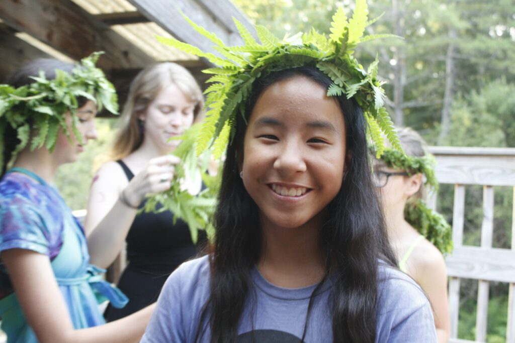 Smiling camper wearing a crown of ferns at Rowe Camp