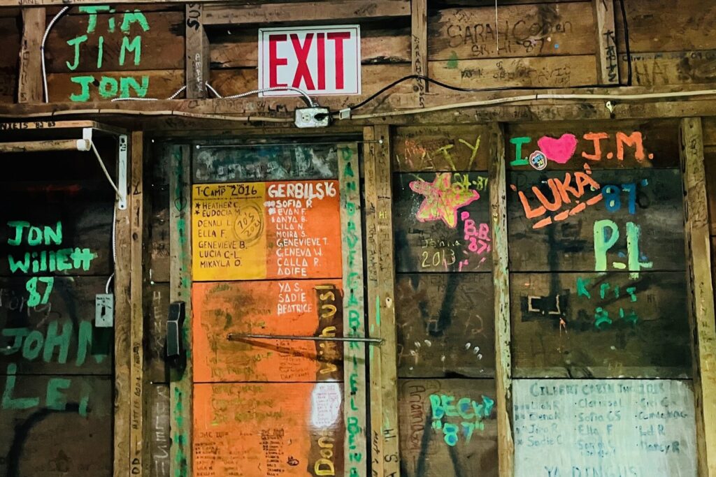 Graffiti on the cabin wall and door at Rowe Camp