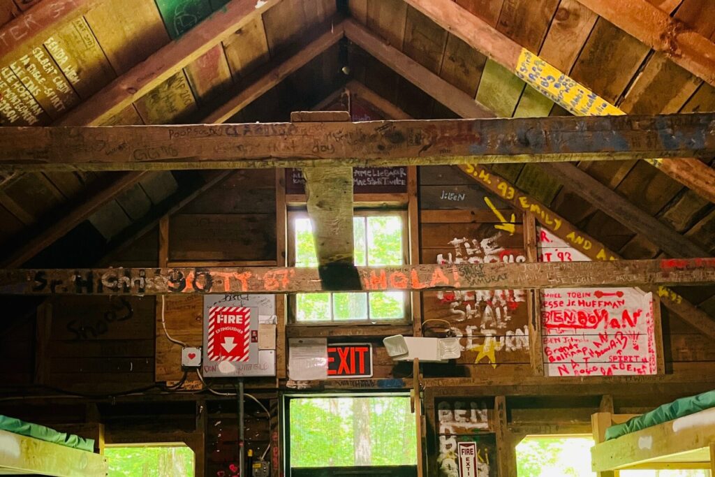 Graffiti on the rafters and walls inside a Rowe Camp cabin