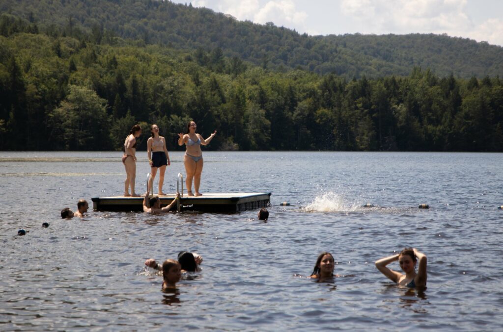 Campers swimming and standing on the dock at Pelham Lake