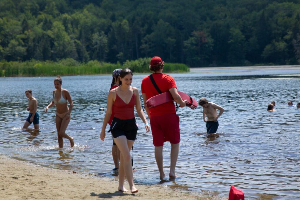 A lifeguard and campers walking out of Pelham Lake